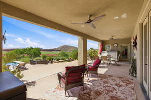 View of patio with outdoor lounge area, ceiling fan, and a mountain view