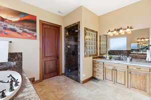 Full bath featuring a garden tub, vanity, and a stall shower