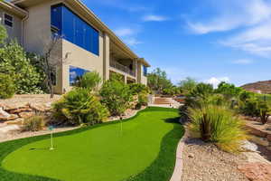View of property's community featuring a putting area and a balcony