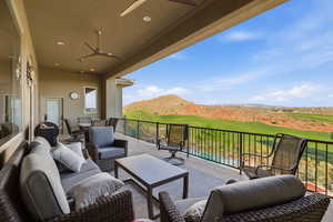 View of patio / terrace featuring a ceiling fan, outdoor seating, a mountain view, and view of golf course