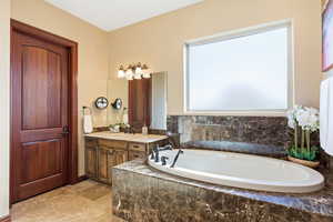 Bathroom featuring vanity and a garden tub