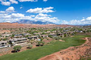 Aerial perspective of suburban area with a mountain backdrop and a golf club