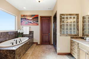 Bathroom featuring a bath, a stall shower, and vanity