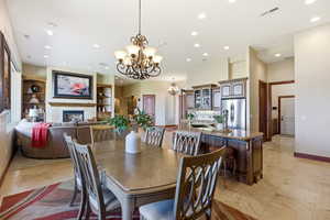 Dining area with a fireplace, suspended lighting, and built in shelves