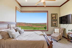 Bedroom with carpet, ornamental molding, and ceiling fan