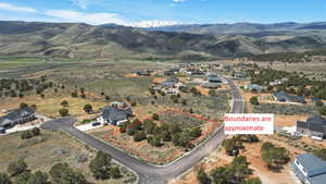 Aerial perspective of suburban area featuring property boundaries highlighted (boundaries are approximate) and a mountainous background