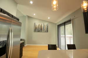 Dining space with vaulted ceiling, recessed lighting, and light wood-type flooring