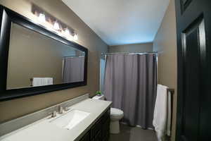 Bathroom with vanity, a shower with shower curtain, and a textured ceiling