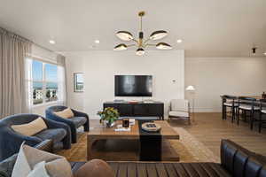Living area with wood finished floors and suspended lighting