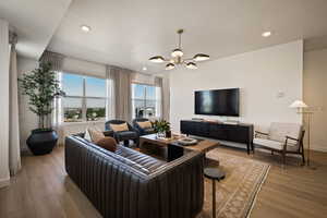 Living area with hanging lights and hardwood / wood-style floors