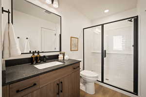 Full bathroom featuring vanity, a shower stall, light wood finished floors, and recessed lighting