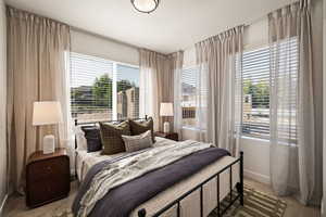 Bedroom featuring light carpet and baseboards
