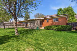 Back of house featuring a fenced backyard and brick siding