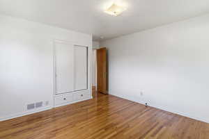 Unfurnished bedroom with hardwood / wood-style floors and a closet