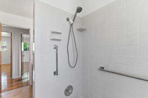 Full bath with tiled shower and baseboards