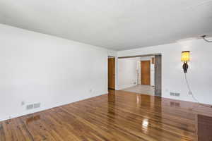 Empty room featuring a textured ceiling and hardwood / wood-style floors