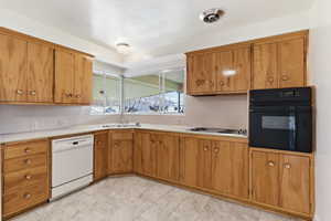 Kitchen with oven, light countertops, wood finish cabinetry, dishwasher, and stainless steel electric cooktop