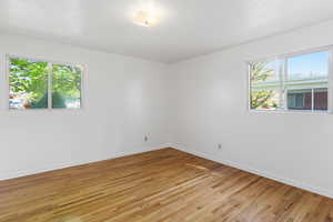 Unfurnished room featuring light wood finished floors and baseboards