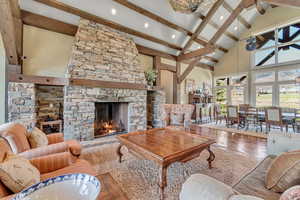 Living room featuring hardwood / wood-style floors, a fireplace, vaulted ceiling, and recessed lighting