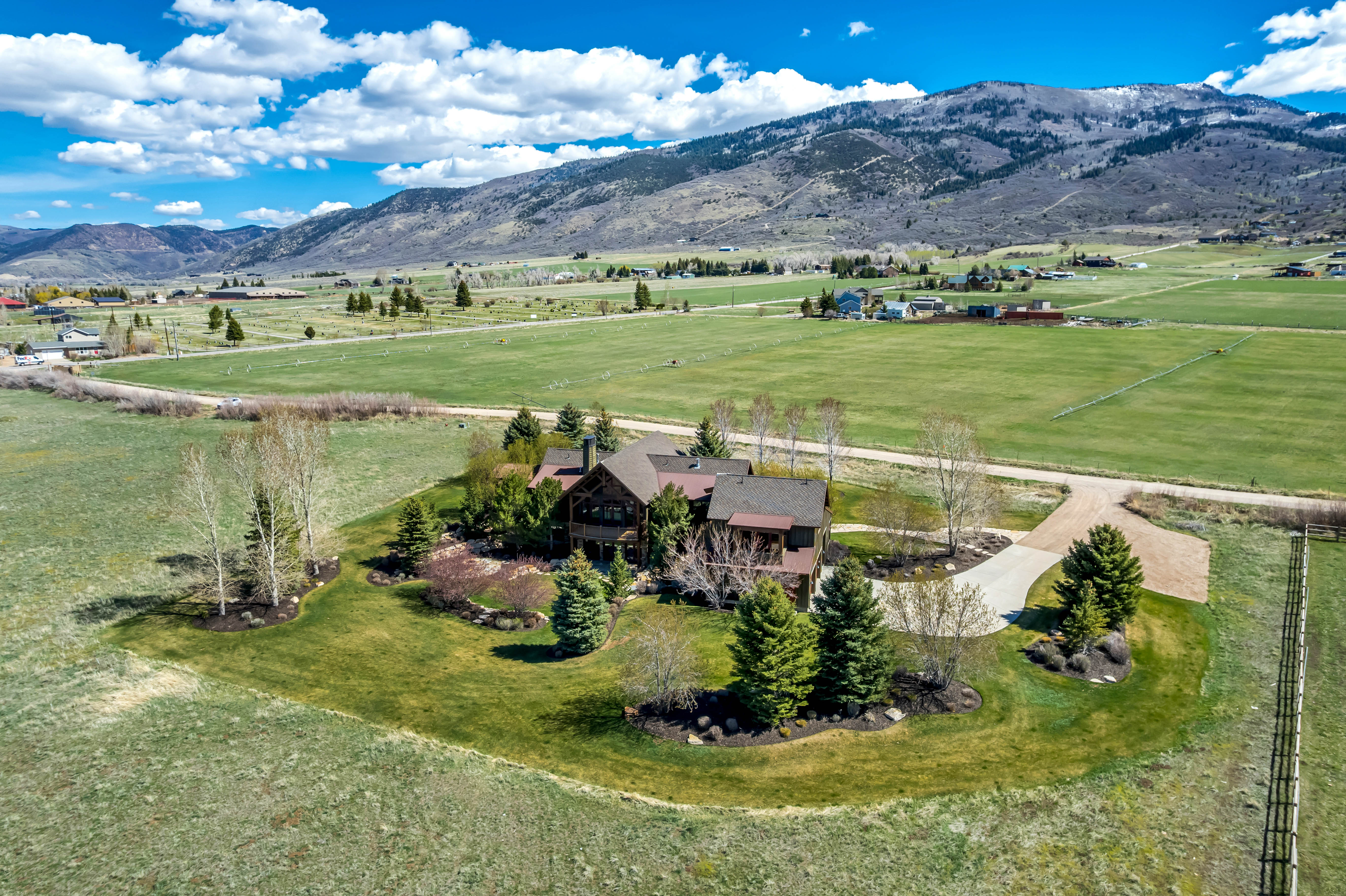 Aerial view of sparsely populated area with a pastoral area and a mountainous background