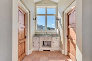 Bathroom featuring vanity, light tile patterned flooring, a mountain view, and lofted ceiling