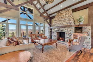 Living room featuring a mountain view, a fireplace, hardwood / wood-style floors, and lofted ceiling