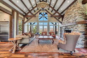 Living room featuring a stone fireplace, a mountain view, and dark wood-style flooring