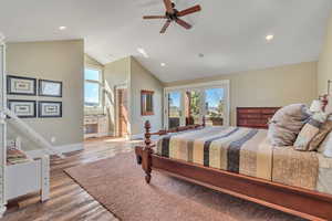 Bedroom with access to outside, light wood finished floors, ceiling fan, recessed lighting, and lofted ceiling