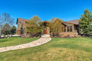 View of front facade featuring a front lawn and roof with shingles