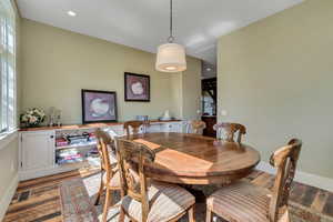 Dining space with wood finished floors and recessed lighting