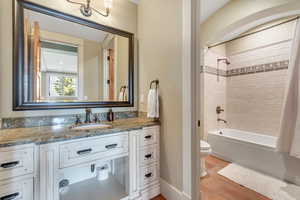 Full bathroom featuring vanity, shower / bath combo with shower curtain, and light tile patterned flooring
