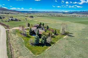 Aerial view of sparsely populated area with a mountain backdrop and agricultural land
