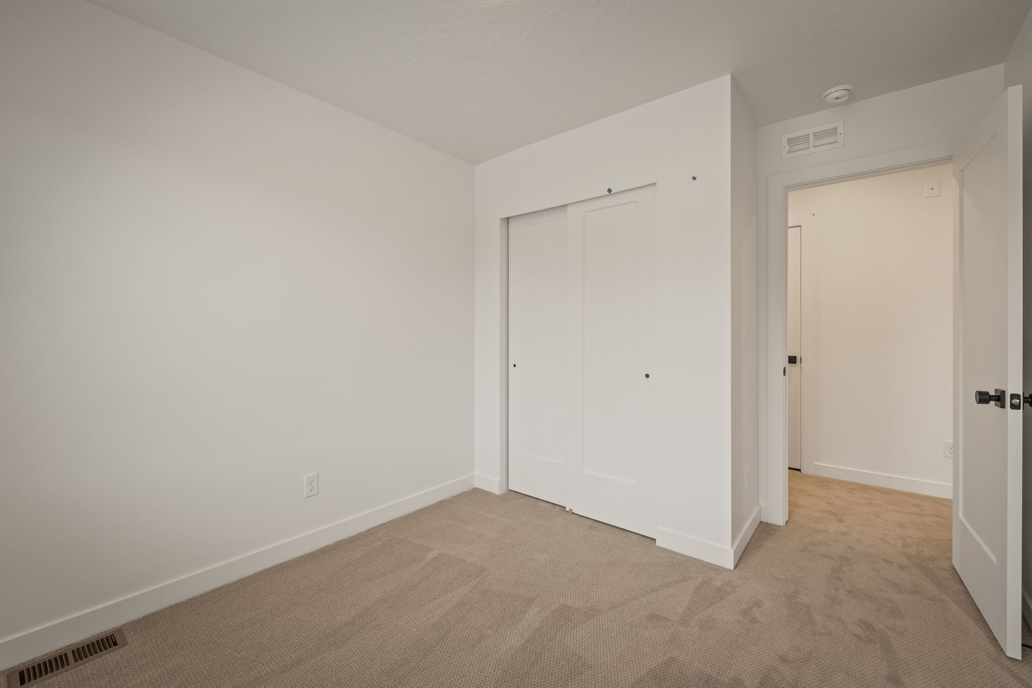 Neutral-toned carpeting complements bright white walls and trim