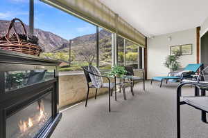 Sunroom / solarium with a mountain view and a glass covered fireplace