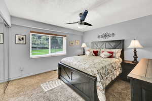Carpeted large bedroom featuring ceiling fan