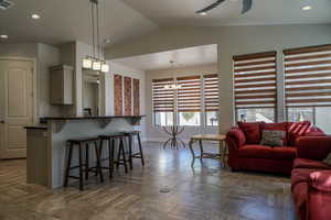 Great Room featuring stone tile floors, vaulted ceiling, ceiling fan,