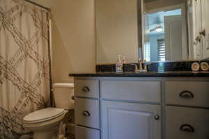 Full bath featuring vanity, a shower with curtain, and a ceiling fan
