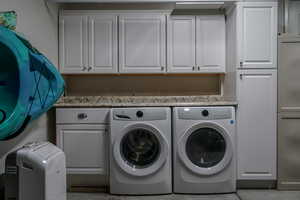 Laundry area with washer and clothes dryer and cabinet space