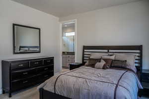 Primary Bedroom featuring light colored carpet and ensuite bath