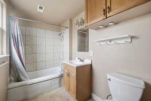 Full bath with vanity, shower / bath combination with curtain, and light tile patterned flooring