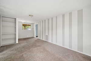 Empty room with carpet floors and wallpapered walls