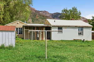 Back of property featuring a mountain view, a yard, concrete block siding, and a metal roof