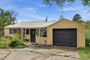 View of front of house featuring a metal roof and an attached garage