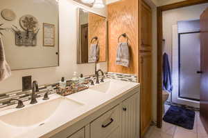 Updated Primary bedroom ensuite Bathroom with a shower, double vanity, and tile backsplash and linen cabinet