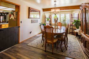 Spacious formal dining with large view bay window, framed by wood beam. Half door opens to kitchen & great rm
