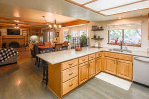 View one of kitchen, casual dining space and family room. Anchored by lovely brick fireplace and built in bookcases