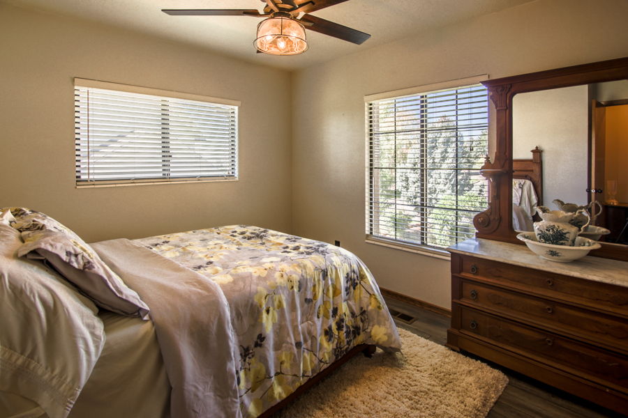 Bedroom #3 with dark wood finished floors and ceiling fan. Lots of light with valley and mountain views