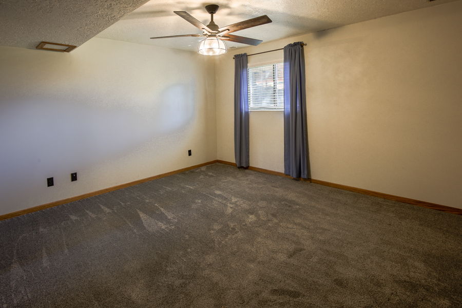 4th bedroom, has above ground window to backyard, ceiling fan and mirrored closet doors