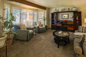 The room is architecturally framed by a boxed wall of view windows showcased by a beautiful beam. Plantation shutters.