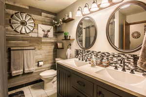 Full updated main bathroom with double vanity, tile backsplash, designer touches, shelves & tub/shower combo